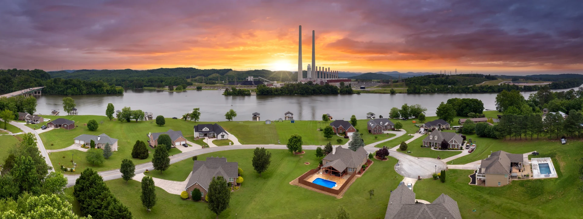 Aerial view of Roane County homes, Watts Bar Lake, and a colorful sunset sky
