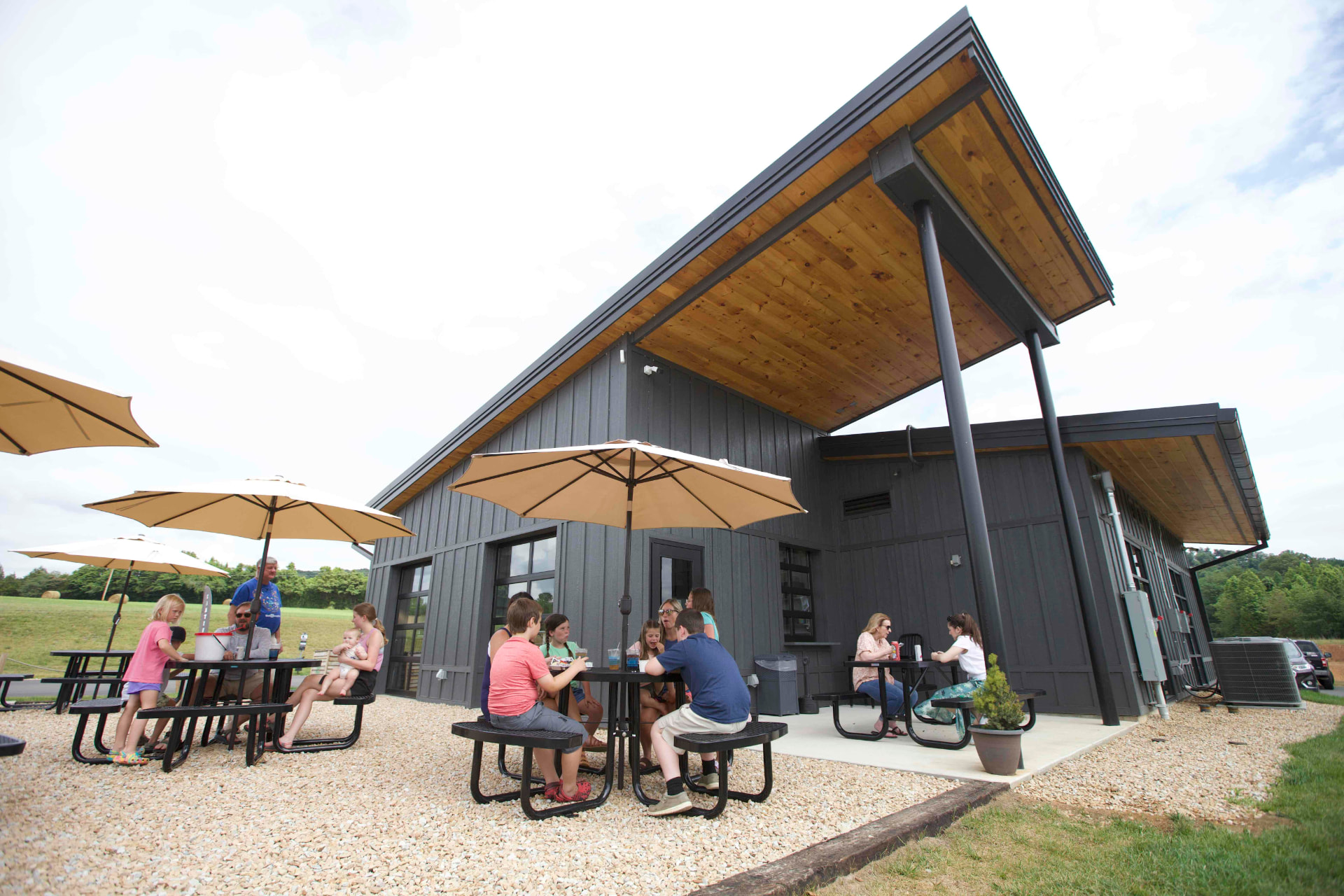 Families and visitors gathered outside a modern Roane County restaurant on a sunny day