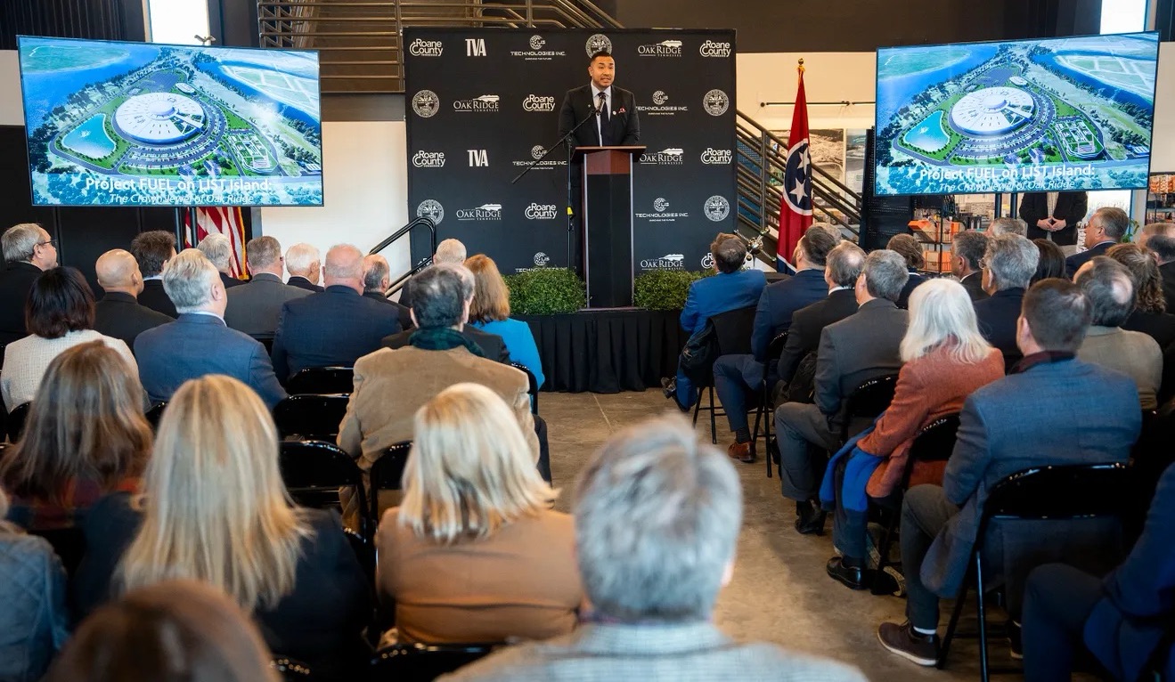 A speaker presents the Project FUEL on LIS Island announcement to an audience in Roane County