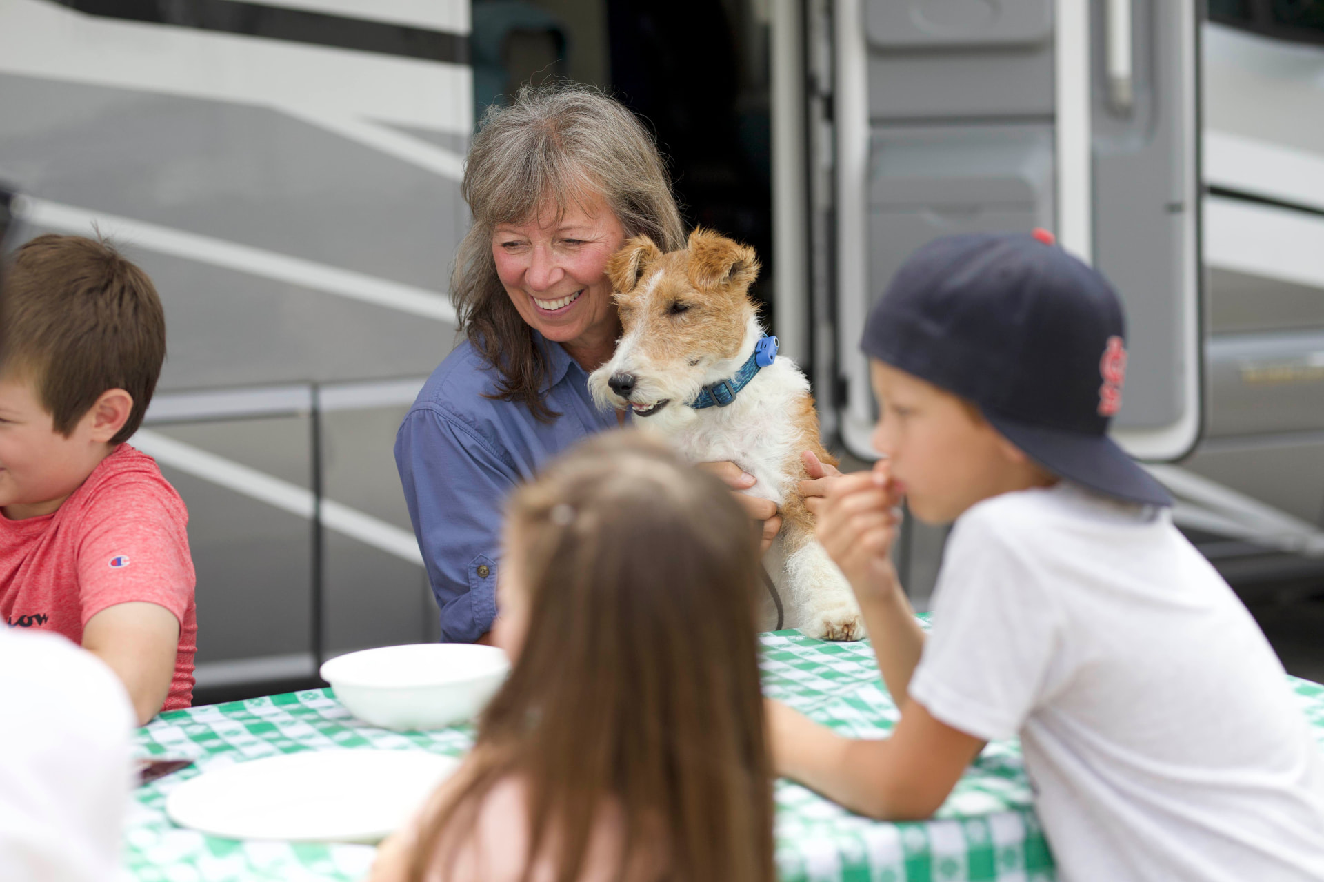 Family gathered around a picnic table with their dog outside an RV in Roane County