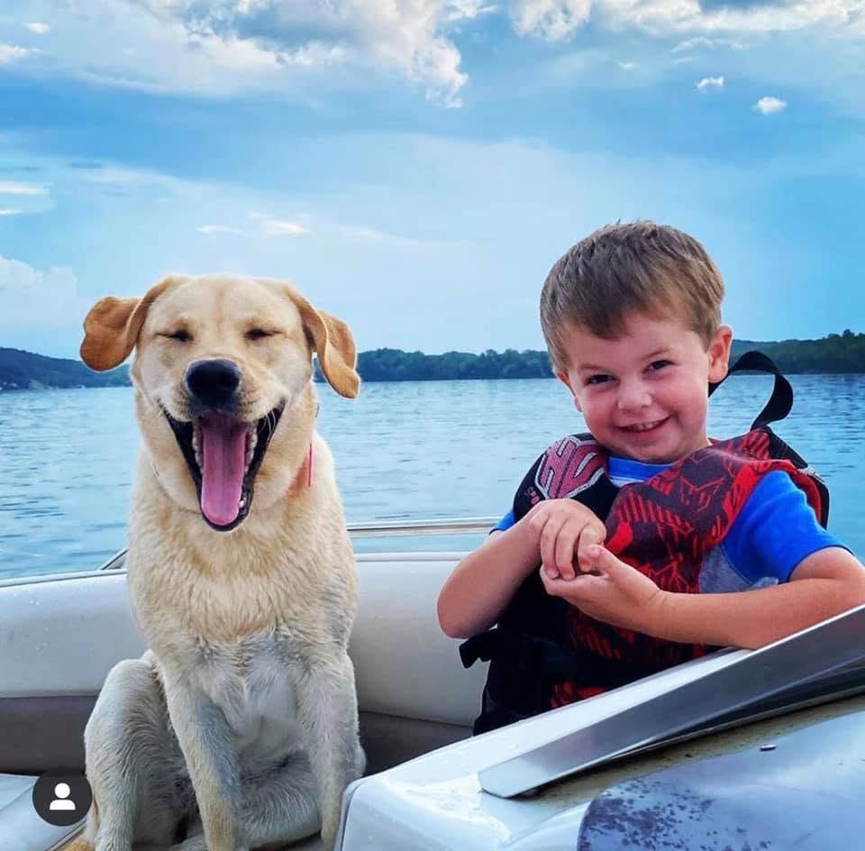 A boy and his dog riding on a boat on Watts Bar Lake